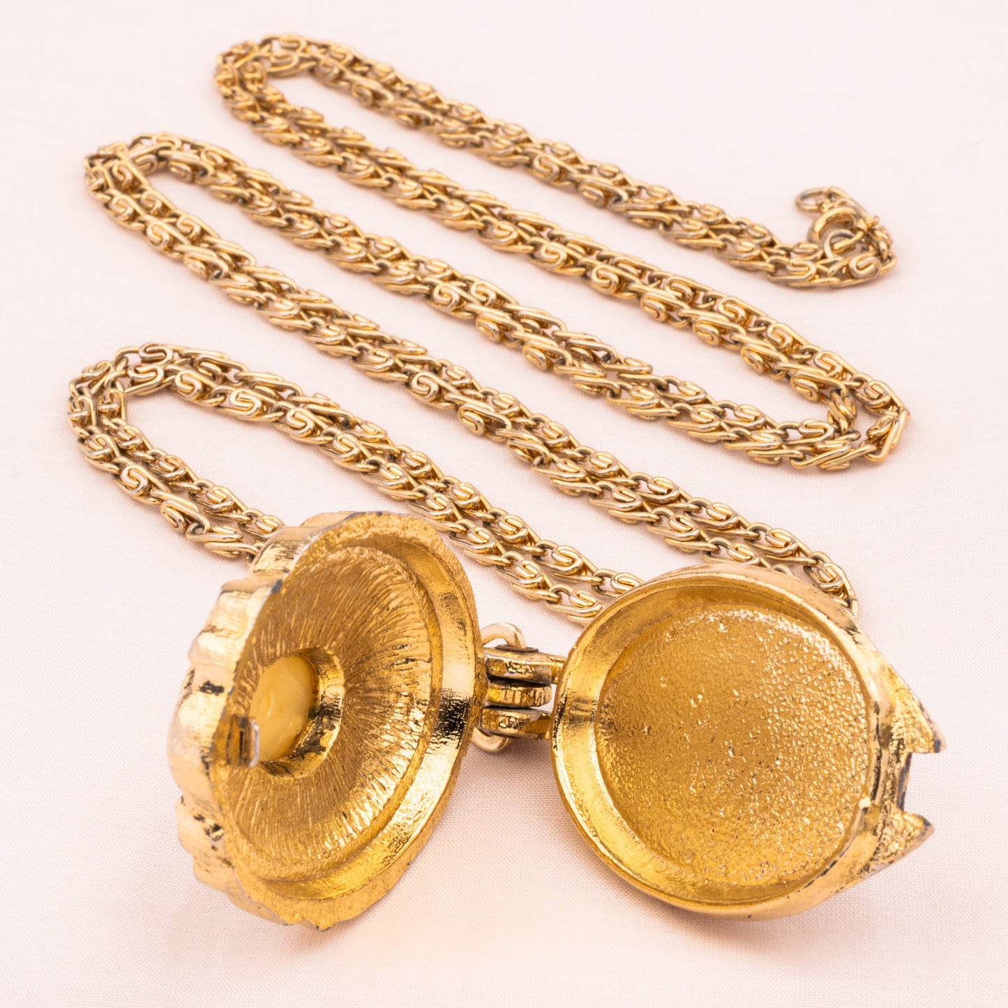 Lange goldfarbene Kette mit offenem Medaillon