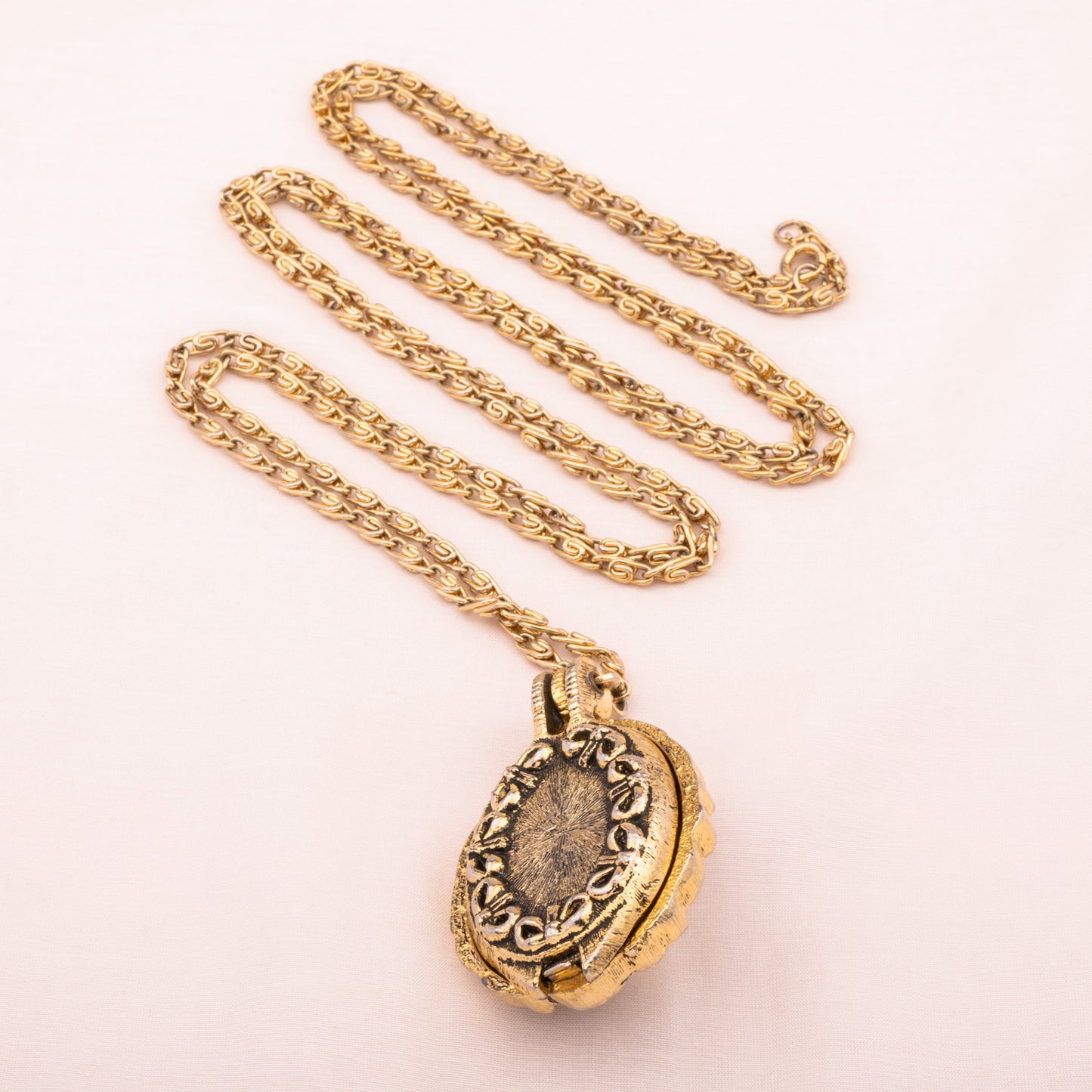 Lange goldfarbene Kette mit Medaillon Rückseite