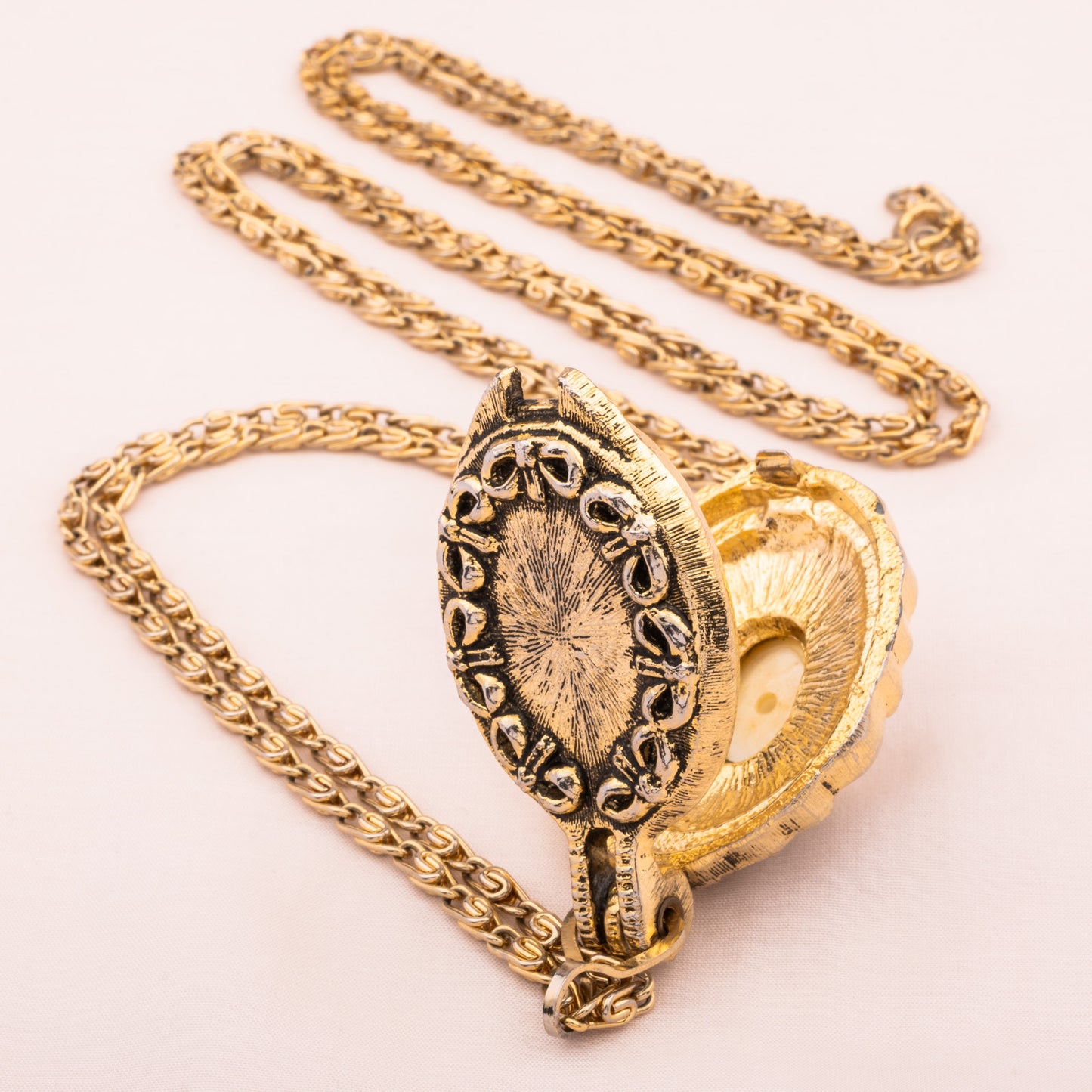 Lange goldfarbene Kette mit offenem Medaillon