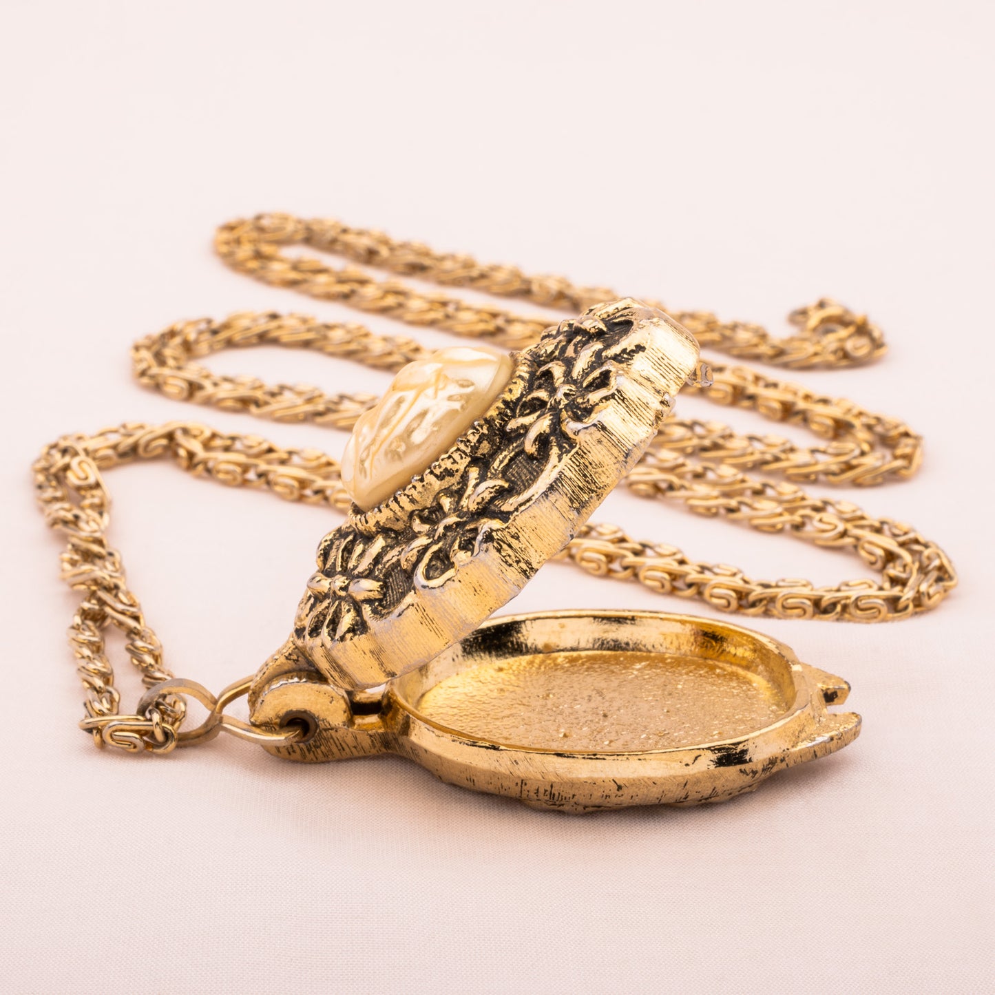 Lange goldfarbene Kette mit offenem Medaillon