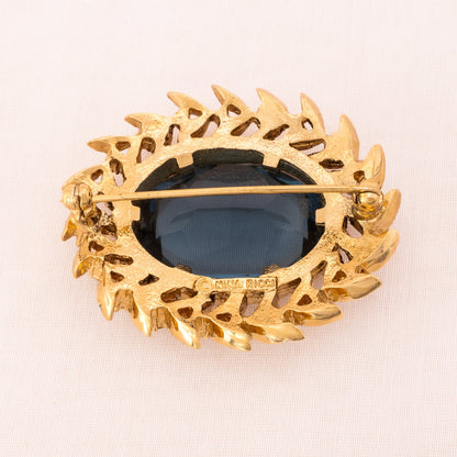 Nina-Ricci-ovale-Brosche-blauer-Kristall-vergoldete-Rückseite-Signatur
