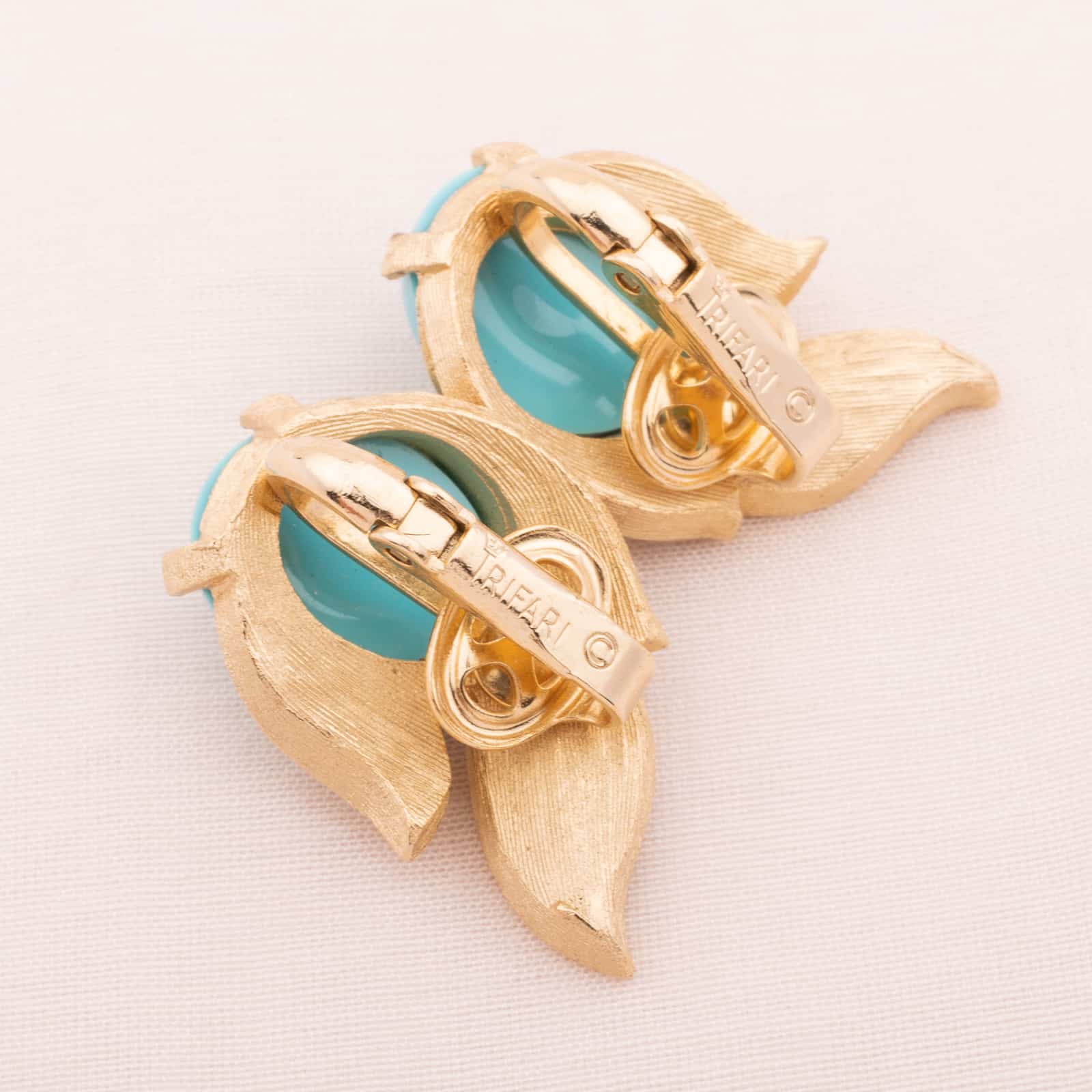 Trifari-goldfarbene-Ohrclips-mit-türkisfarbenen-Cabochons-60s-Signatur